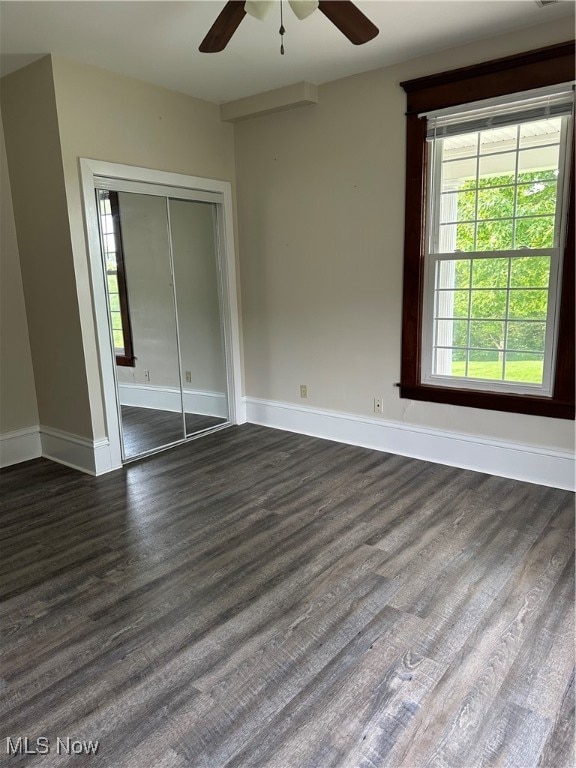 unfurnished bedroom with dark hardwood / wood-style floors, ceiling fan, and a closet