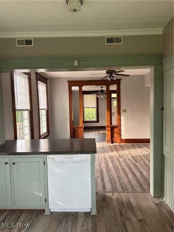 kitchen with crown molding, white dishwasher, and hardwood / wood-style flooring