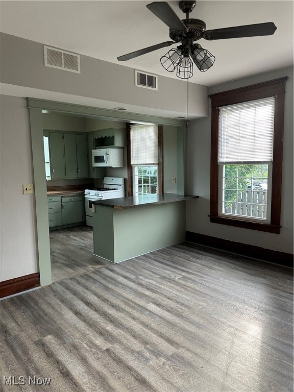 kitchen featuring light wood-type flooring, green cabinetry, kitchen peninsula, white appliances, and ceiling fan