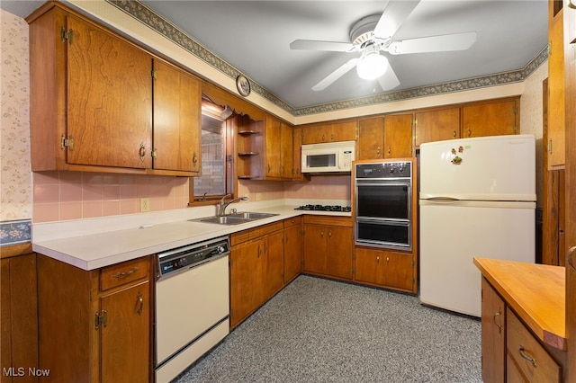 kitchen with white appliances, ceiling fan, and sink