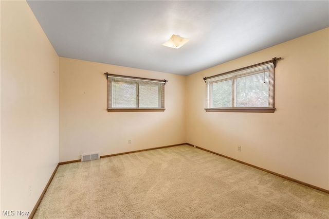 spare room with a healthy amount of sunlight and light colored carpet