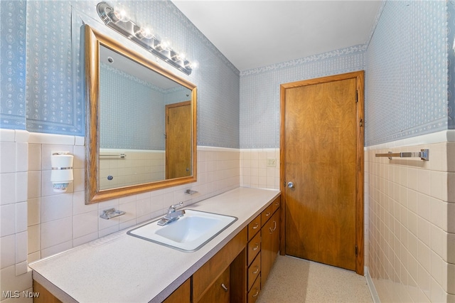 bathroom featuring vanity and tile walls