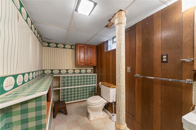 bathroom featuring wood walls and toilet