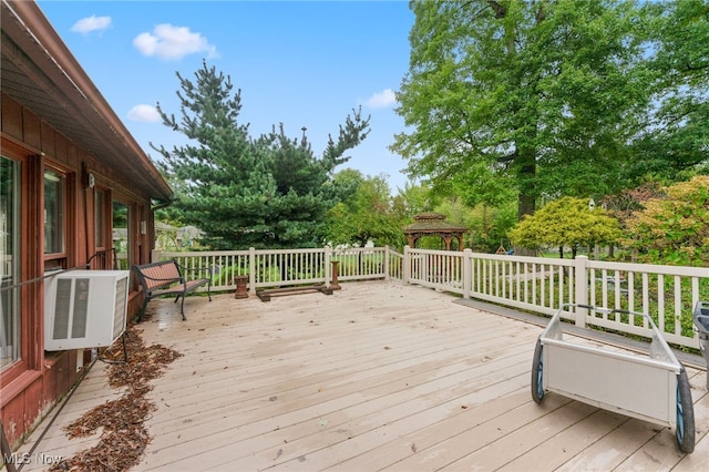 wooden deck featuring cooling unit and a gazebo