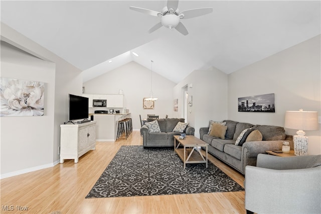 living room with ceiling fan, light hardwood / wood-style flooring, and lofted ceiling