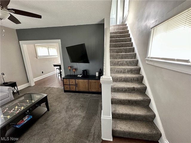 staircase featuring ceiling fan, hardwood / wood-style floors, and a textured ceiling