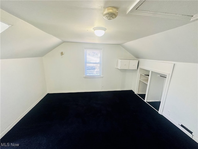 bonus room with lofted ceiling and carpet flooring