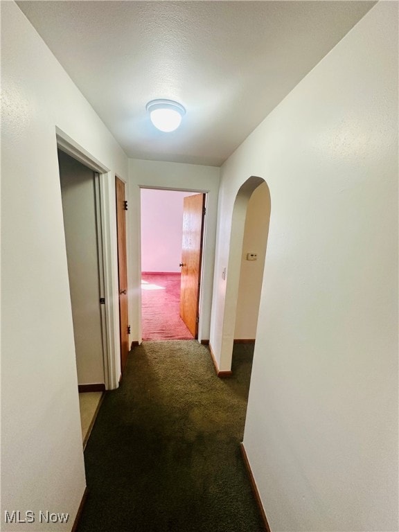 corridor featuring dark colored carpet