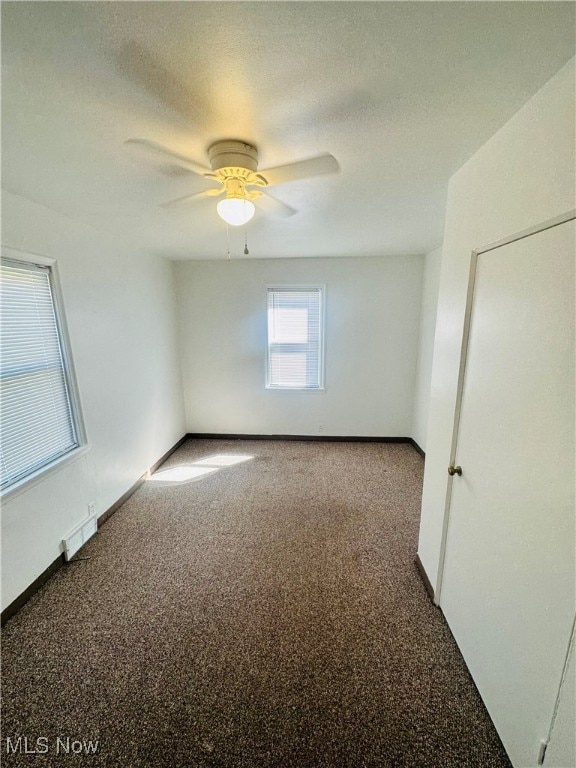 unfurnished room featuring ceiling fan, carpet floors, and a textured ceiling