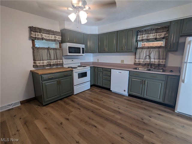 kitchen featuring ceiling fan, sink, white appliances, butcher block countertops, and dark wood-type flooring