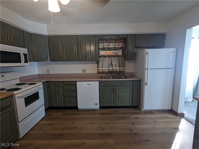 kitchen featuring white appliances, dark hardwood / wood-style floors, ceiling fan, and sink