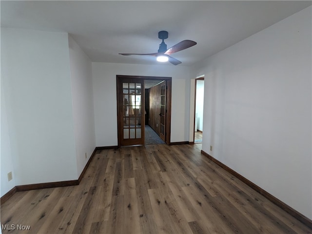 unfurnished room with ceiling fan and dark wood-type flooring