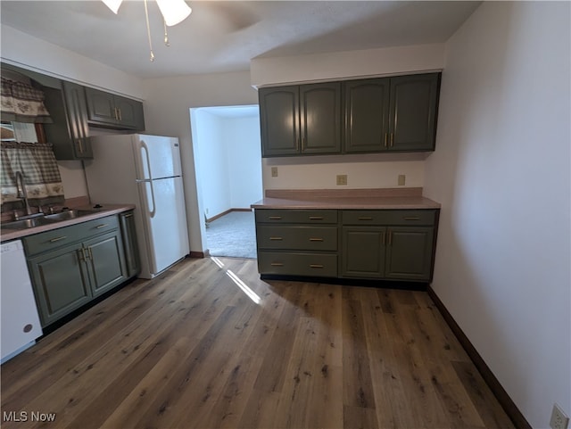 kitchen with white appliances, ceiling fan, dark hardwood / wood-style floors, and sink