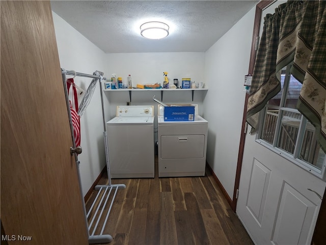 clothes washing area with washer and clothes dryer, a textured ceiling, and dark hardwood / wood-style flooring