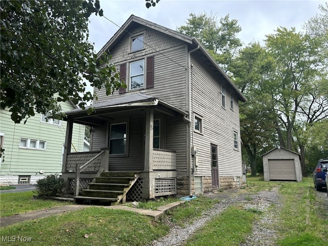 view of front facade with a garage, covered porch, and an outbuilding