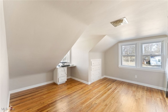 bonus room with lofted ceiling and light hardwood / wood-style flooring