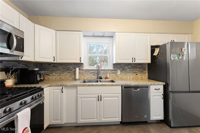 kitchen featuring white cabinetry, stainless steel appliances, sink, and tasteful backsplash