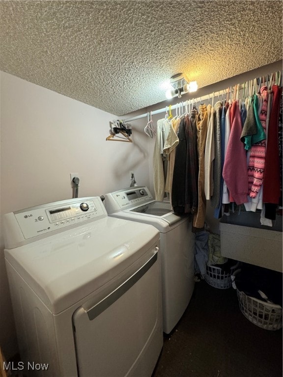 laundry room featuring a textured ceiling and washing machine and clothes dryer