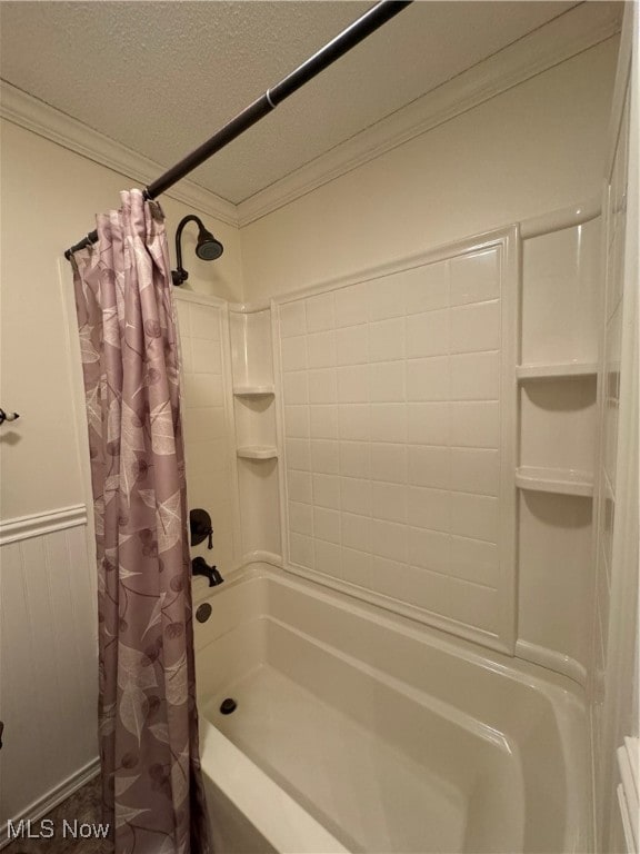 bathroom with shower / bathtub combination with curtain, a textured ceiling, and ornamental molding