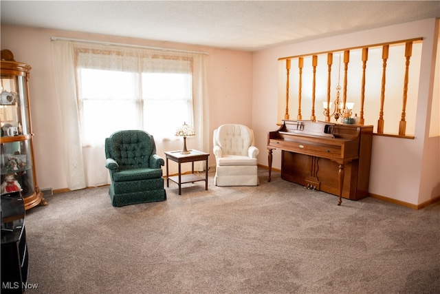 sitting room featuring carpet floors and an inviting chandelier