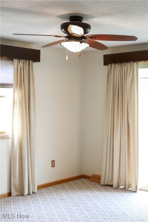 carpeted spare room with ceiling fan and a textured ceiling