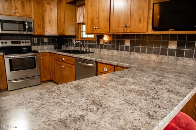 kitchen with decorative backsplash, sink, light stone countertops, and appliances with stainless steel finishes