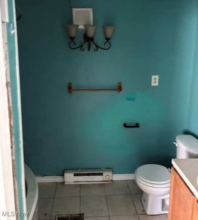 bathroom with vanity, toilet, a baseboard heating unit, and tile patterned floors