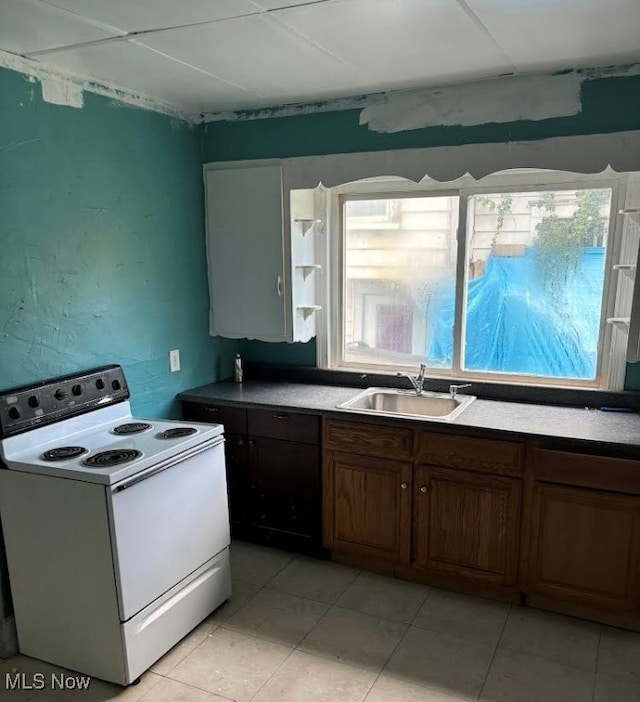 kitchen featuring electric stove, light tile patterned flooring, and sink