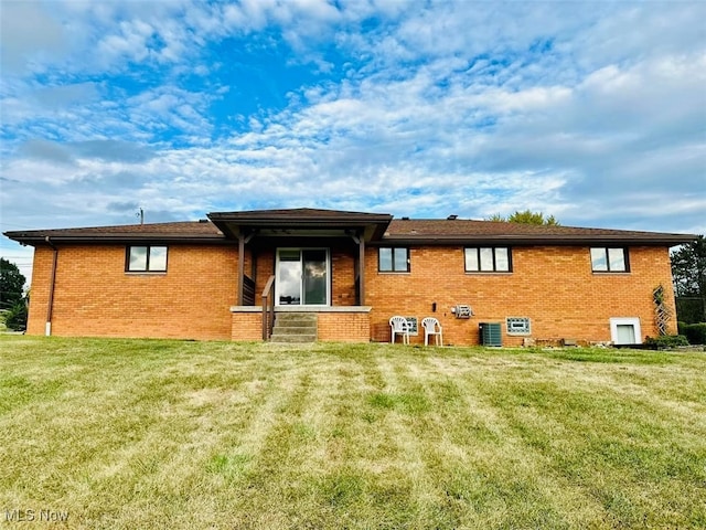 rear view of house with a yard and central AC