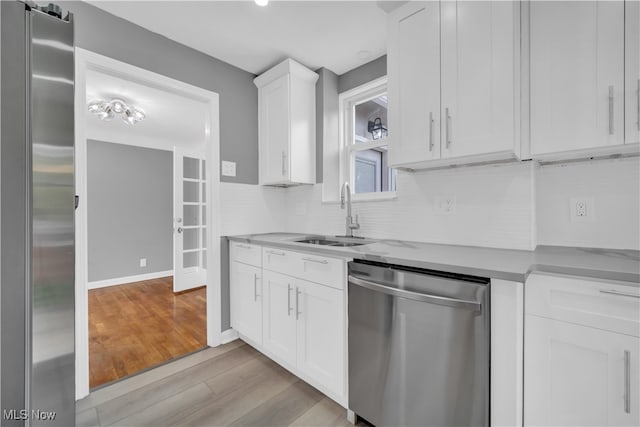 kitchen with light hardwood / wood-style flooring, stainless steel appliances, sink, and white cabinetry