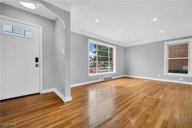 entrance foyer featuring ornamental molding and light hardwood / wood-style floors