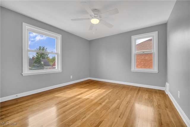 empty room with light wood-type flooring, ceiling fan, and plenty of natural light