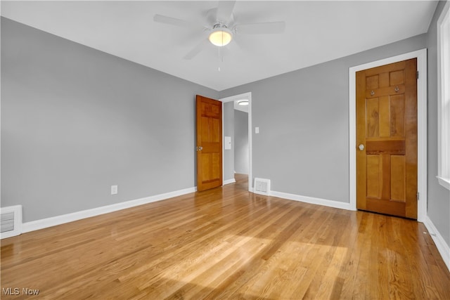 empty room with ceiling fan and light hardwood / wood-style flooring