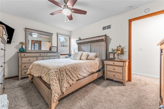 carpeted bedroom with ceiling fan and a textured ceiling