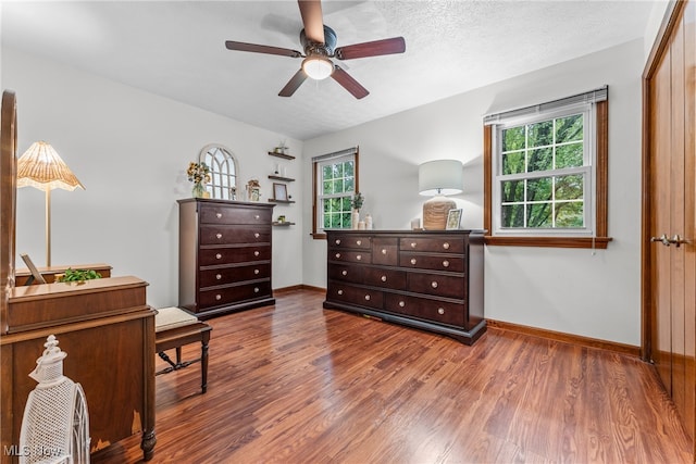 living area featuring ceiling fan, a textured ceiling, and hardwood / wood-style floors