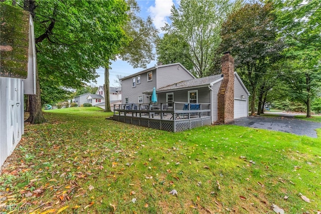 rear view of house with a lawn and a wooden deck