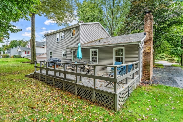 back of house with a yard, a garage, and a wooden deck