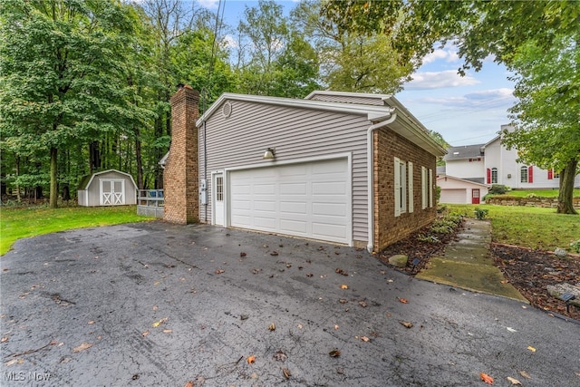 view of home's exterior with a garage, a yard, and a storage unit