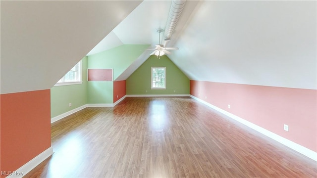 additional living space with ceiling fan, plenty of natural light, lofted ceiling, and light hardwood / wood-style flooring