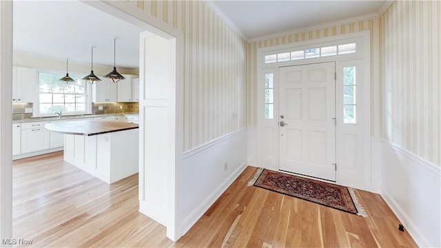 entrance foyer featuring light wood-type flooring and crown molding