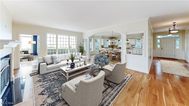 living room featuring light wood-type flooring and ornamental molding