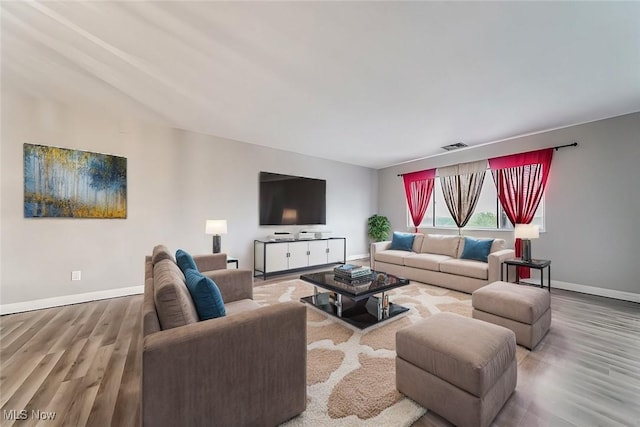 living room with wood-type flooring and vaulted ceiling