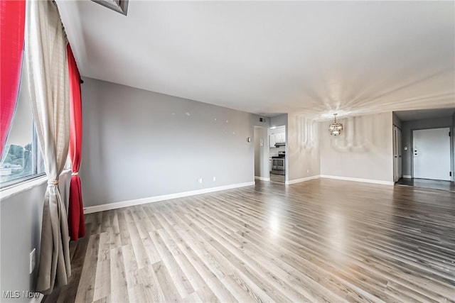 unfurnished living room with light hardwood / wood-style floors and an inviting chandelier