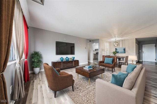 living room with a chandelier and light hardwood / wood-style floors