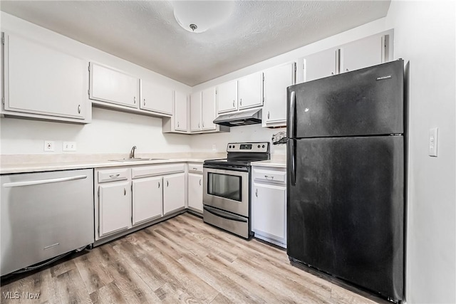 kitchen featuring white cabinets, sink, light wood-type flooring, a textured ceiling, and stainless steel appliances