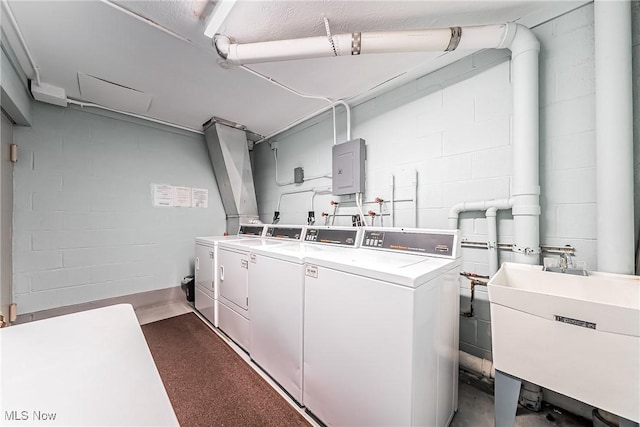 clothes washing area featuring separate washer and dryer, sink, and electric panel