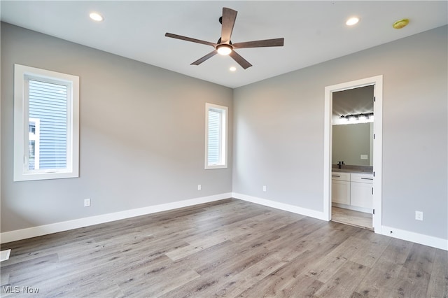 unfurnished bedroom featuring ensuite bathroom, ceiling fan, and light hardwood / wood-style floors