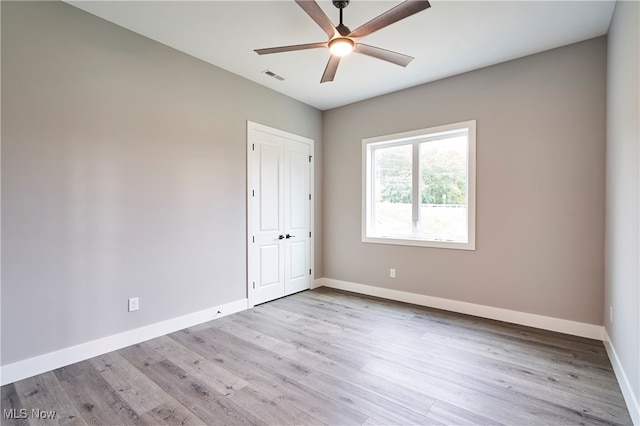 spare room with ceiling fan and light wood-type flooring