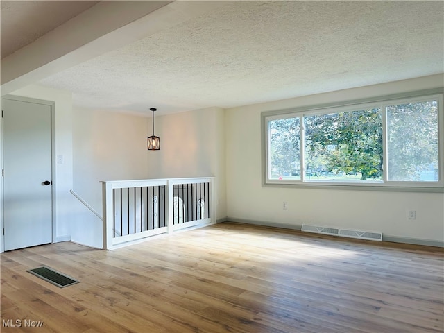 empty room featuring light hardwood / wood-style flooring and a textured ceiling