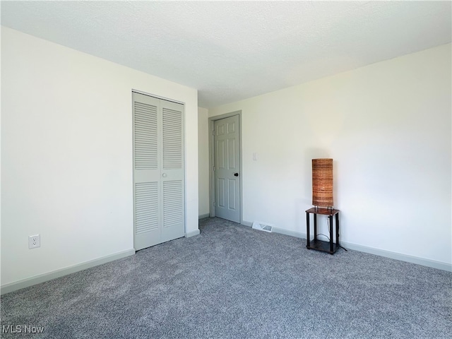 unfurnished bedroom with a textured ceiling and carpet flooring